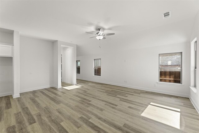 unfurnished living room featuring light hardwood / wood-style flooring, ceiling fan, and plenty of natural light