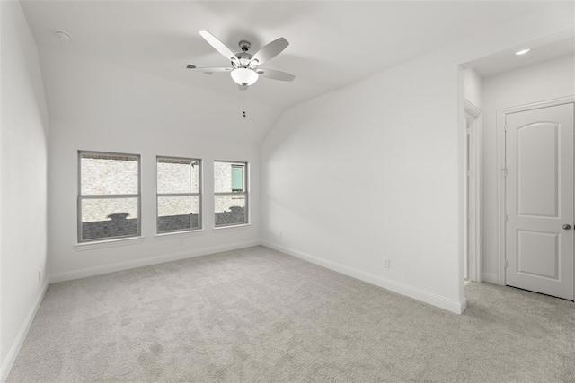 spare room featuring light carpet, ceiling fan, and lofted ceiling