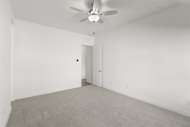 empty room featuring ceiling fan and light carpet