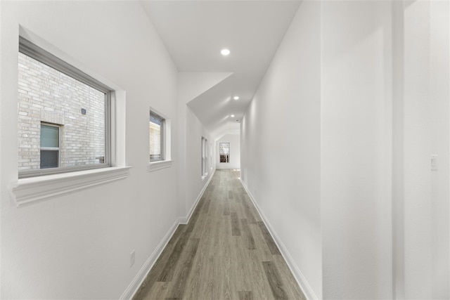 hallway featuring hardwood / wood-style flooring and lofted ceiling