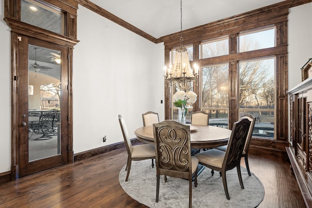 dining space with ceiling fan with notable chandelier, plenty of natural light, dark hardwood / wood-style floors, and crown molding