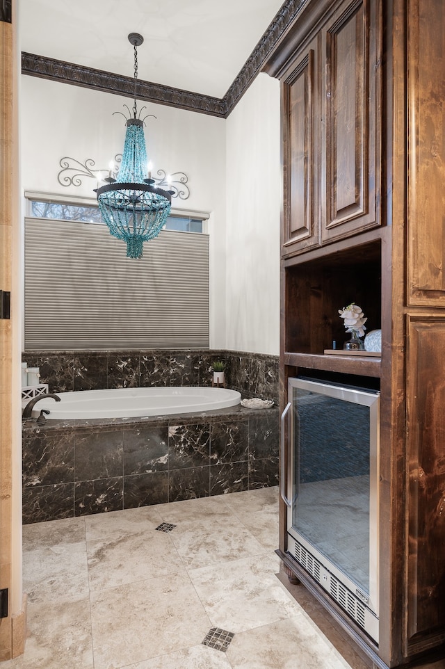 bathroom with crown molding, tiled tub, and a chandelier