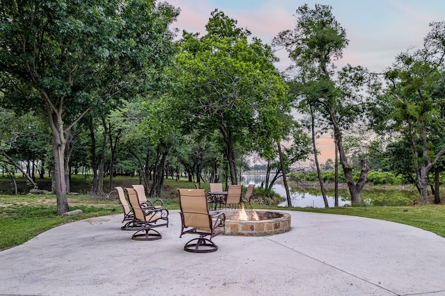 view of home's community featuring a water view, a lawn, a patio area, and a fire pit