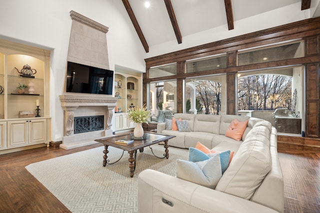 living room with a fireplace, beamed ceiling, high vaulted ceiling, built in features, and dark wood-type flooring