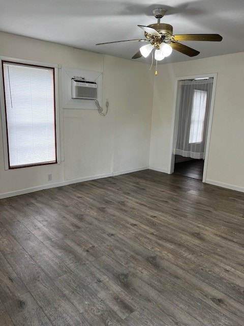 spare room with dark wood-type flooring, ceiling fan, and a wall mounted AC