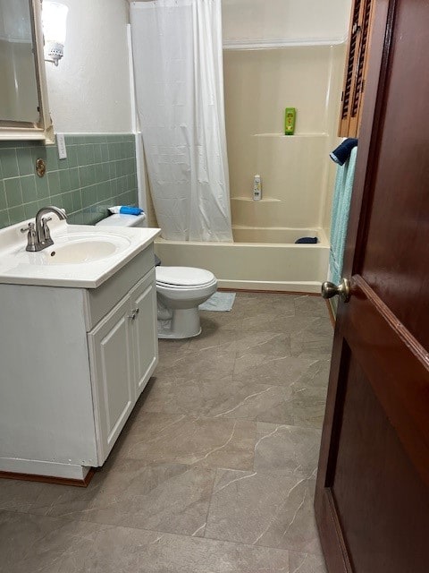 full bathroom with toilet, vanity, backsplash, tile walls, and shower / bath combination with curtain