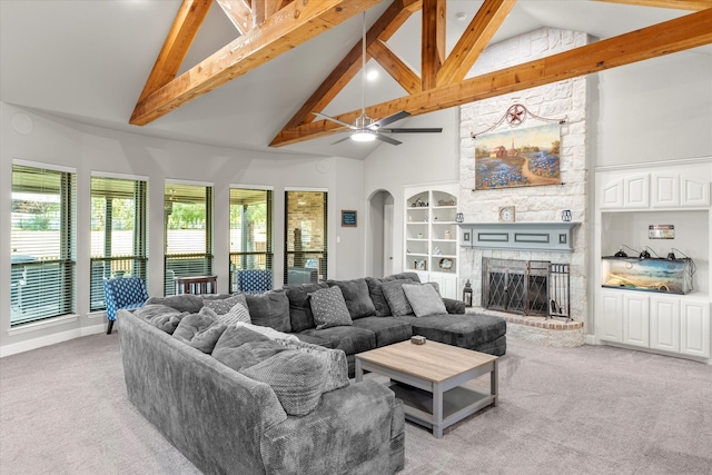 living room featuring carpet, high vaulted ceiling, ceiling fan, and a stone fireplace