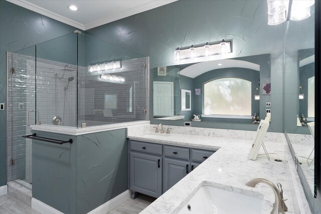 bathroom with ornamental molding, vanity, and a shower with shower door