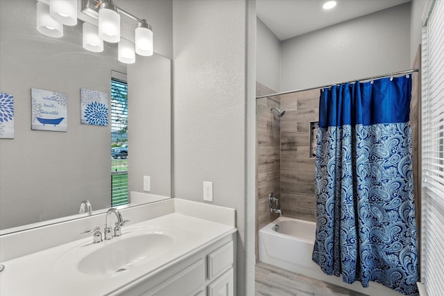 full bathroom with shower / tub combo, a textured wall, wood finished floors, and vanity