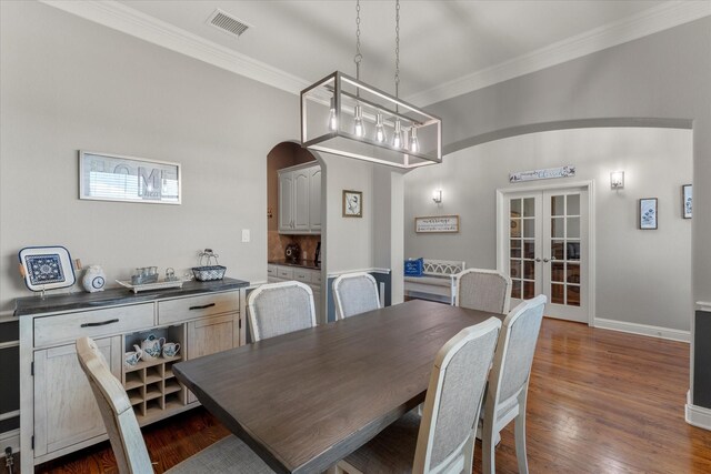 dining room featuring dark wood-type flooring, french doors, and ornamental molding