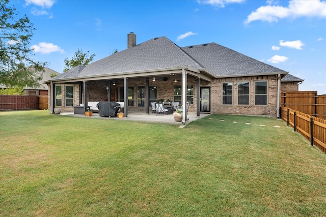 rear view of property with outdoor lounge area, ceiling fan, a lawn, and a patio area