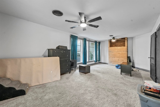 carpeted living room with ceiling fan