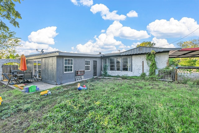 rear view of property featuring a yard and a patio area