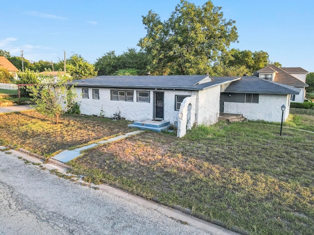 single story home featuring a front lawn