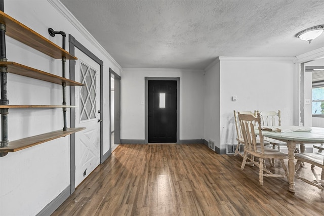 entrance foyer featuring a textured ceiling, crown molding, and dark hardwood / wood-style floors