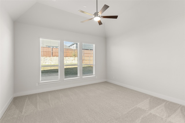 carpeted spare room with ceiling fan and vaulted ceiling