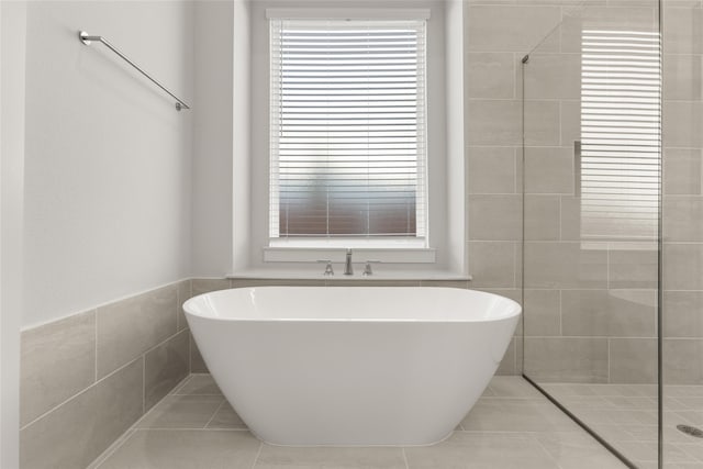 bathroom with tile patterned floors, tile walls, and independent shower and bath