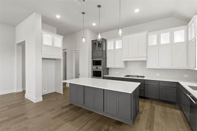 kitchen featuring gray cabinetry, stainless steel appliances, decorative light fixtures, white cabinets, and a kitchen island