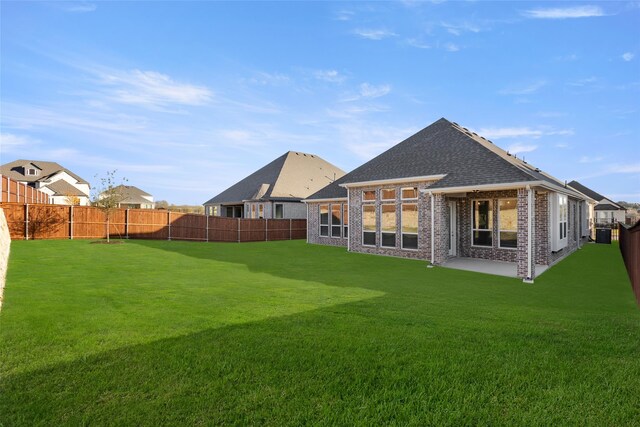 back of house with a patio area and a lawn