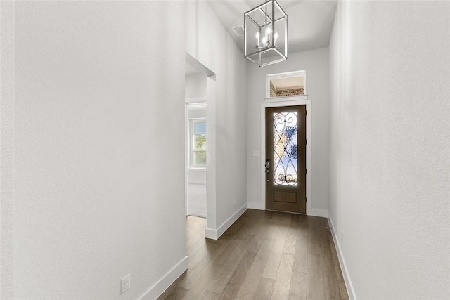 doorway to outside featuring hardwood / wood-style floors and an inviting chandelier