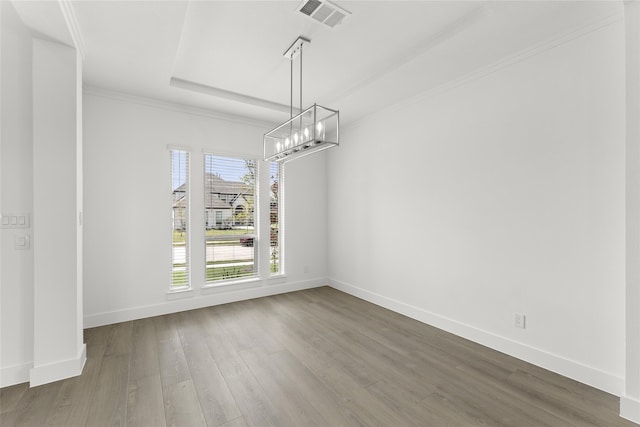 unfurnished dining area with a raised ceiling, wood-type flooring, and a notable chandelier