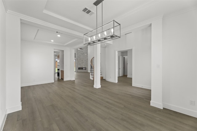 unfurnished dining area featuring dark hardwood / wood-style floors, a raised ceiling, and ornamental molding