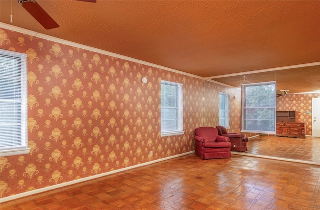 unfurnished room featuring a textured ceiling, a healthy amount of sunlight, ceiling fan, and ornamental molding