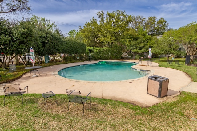 view of swimming pool featuring a yard and a patio