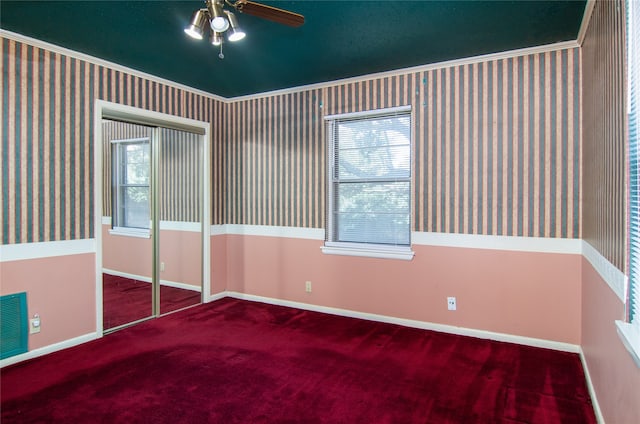 empty room with crown molding, ceiling fan, and carpet floors