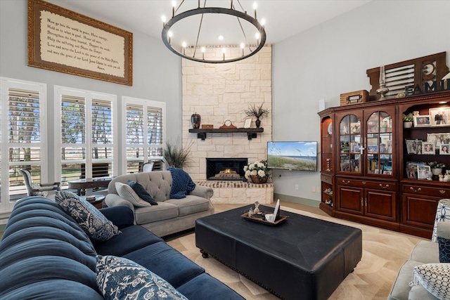 living room with a stone fireplace, a towering ceiling, and an inviting chandelier