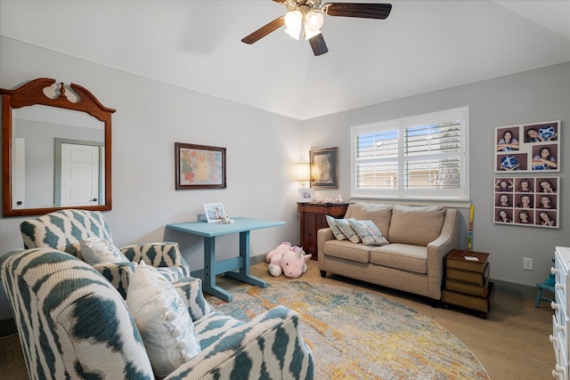 living room featuring ceiling fan, lofted ceiling, and light wood-type flooring