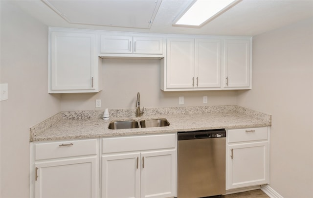 kitchen featuring stainless steel dishwasher, light stone countertops, sink, and white cabinets