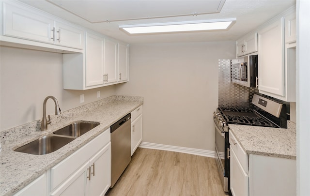 kitchen featuring white cabinets, stainless steel appliances, light hardwood / wood-style floors, and sink