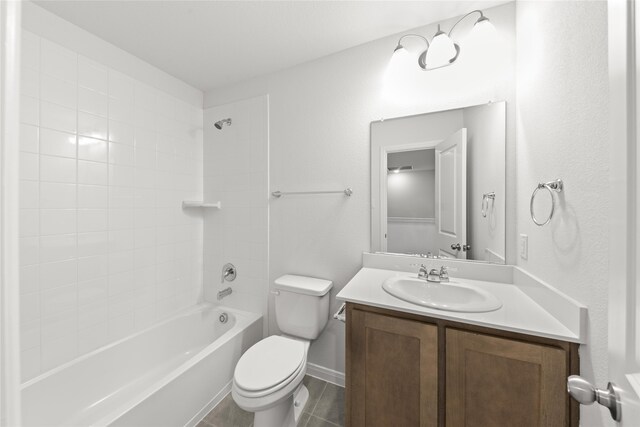 full bathroom featuring tiled shower / bath combo, vanity, toilet, and tile patterned floors