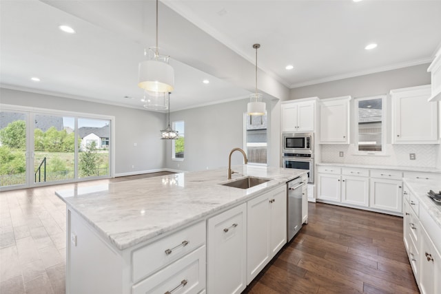 kitchen featuring dark wood-style flooring, decorative backsplash, appliances with stainless steel finishes, white cabinetry, and a sink