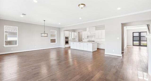 unfurnished living room featuring crown molding, baseboards, dark wood-style flooring, and recessed lighting