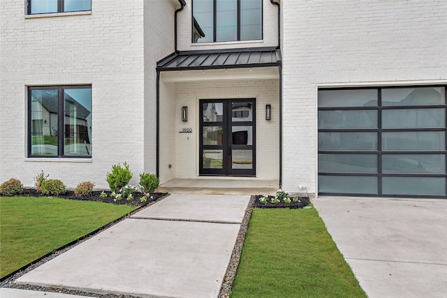 view of exterior entry with a lawn and a garage