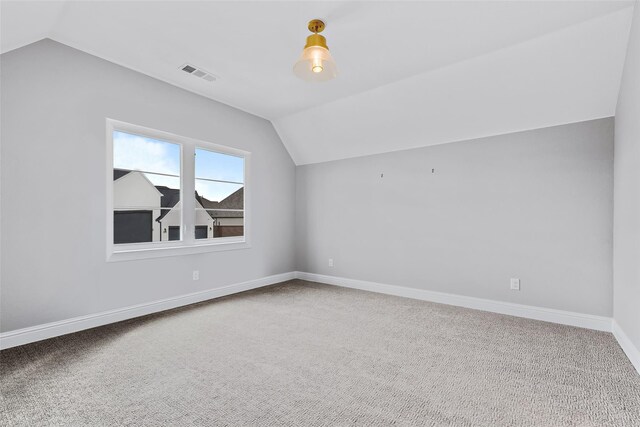 bonus room featuring lofted ceiling, carpet floors, visible vents, and baseboards