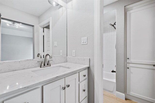 bathroom with shower / washtub combination, vanity, ceiling fan, and hardwood / wood-style flooring