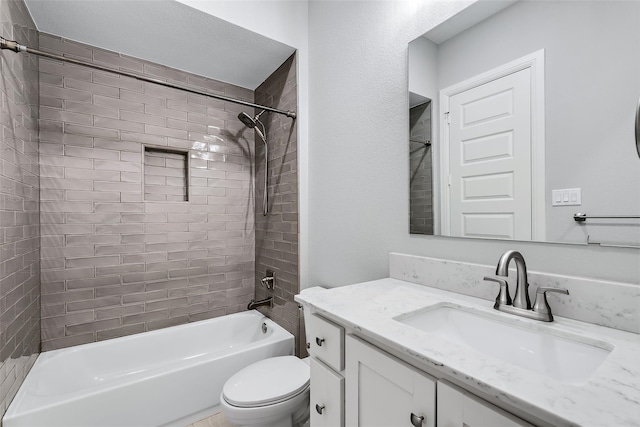 full bathroom featuring tiled shower / bath, vanity, and toilet