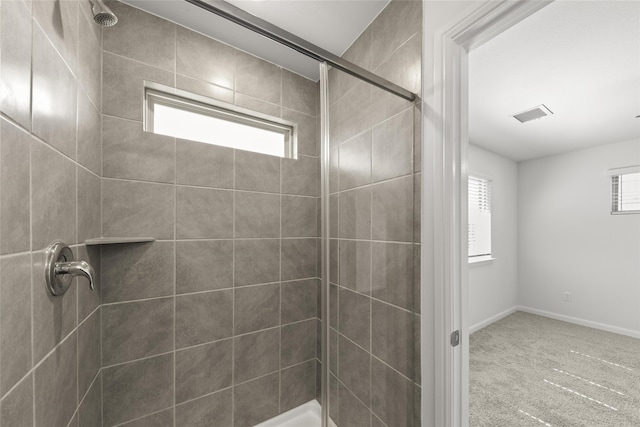 bathroom featuring a tile shower and plenty of natural light