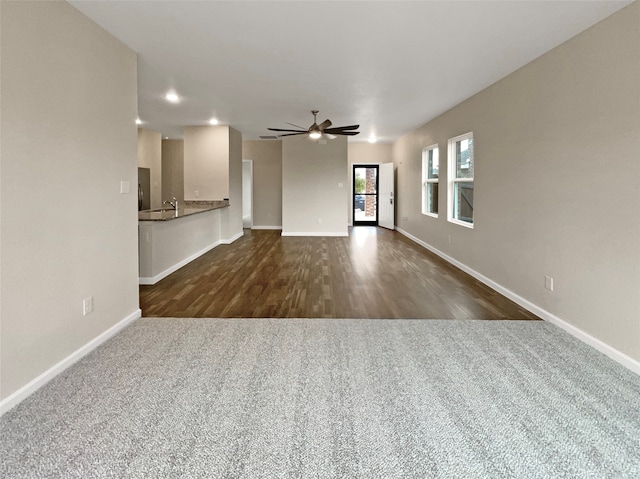 unfurnished living room with ceiling fan and dark hardwood / wood-style flooring