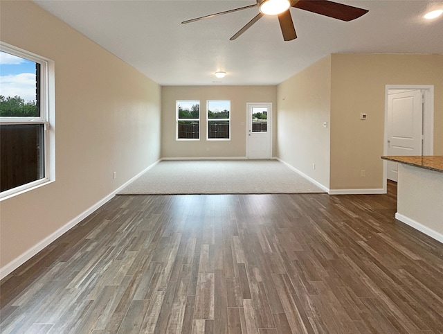 unfurnished living room featuring ceiling fan and dark hardwood / wood-style floors