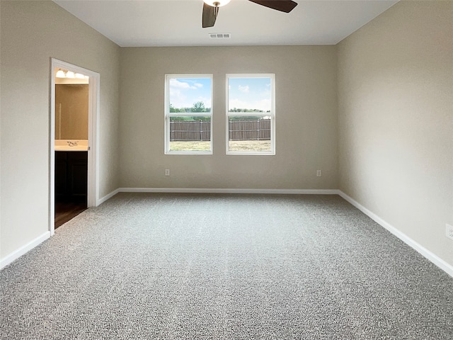 carpeted spare room with ceiling fan