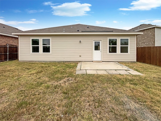 rear view of property featuring a lawn and a patio