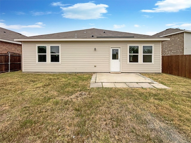 rear view of house with a patio area, a fenced backyard, and a yard