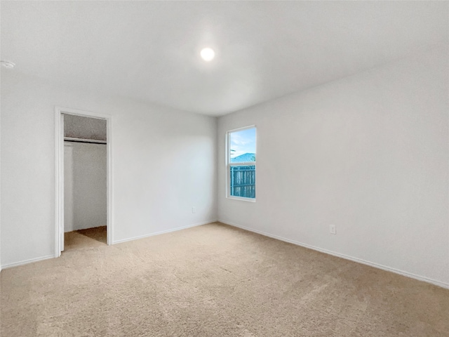 unfurnished bedroom with a closet and light carpet