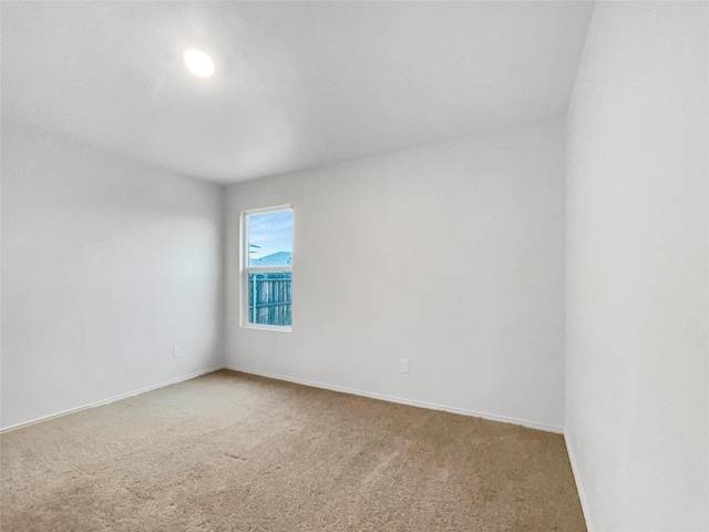 carpeted empty room with baseboards