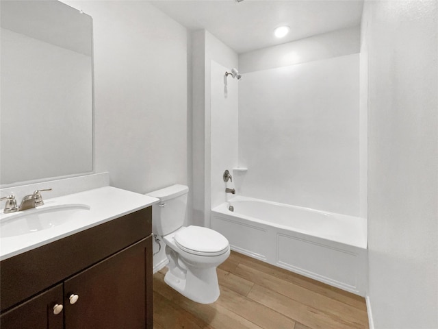 bathroom featuring vanity,  shower combination, toilet, and wood finished floors