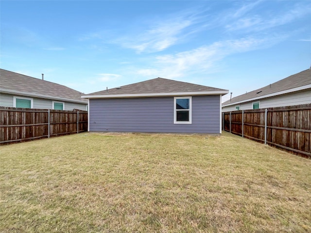 back of house featuring a lawn and a fenced backyard